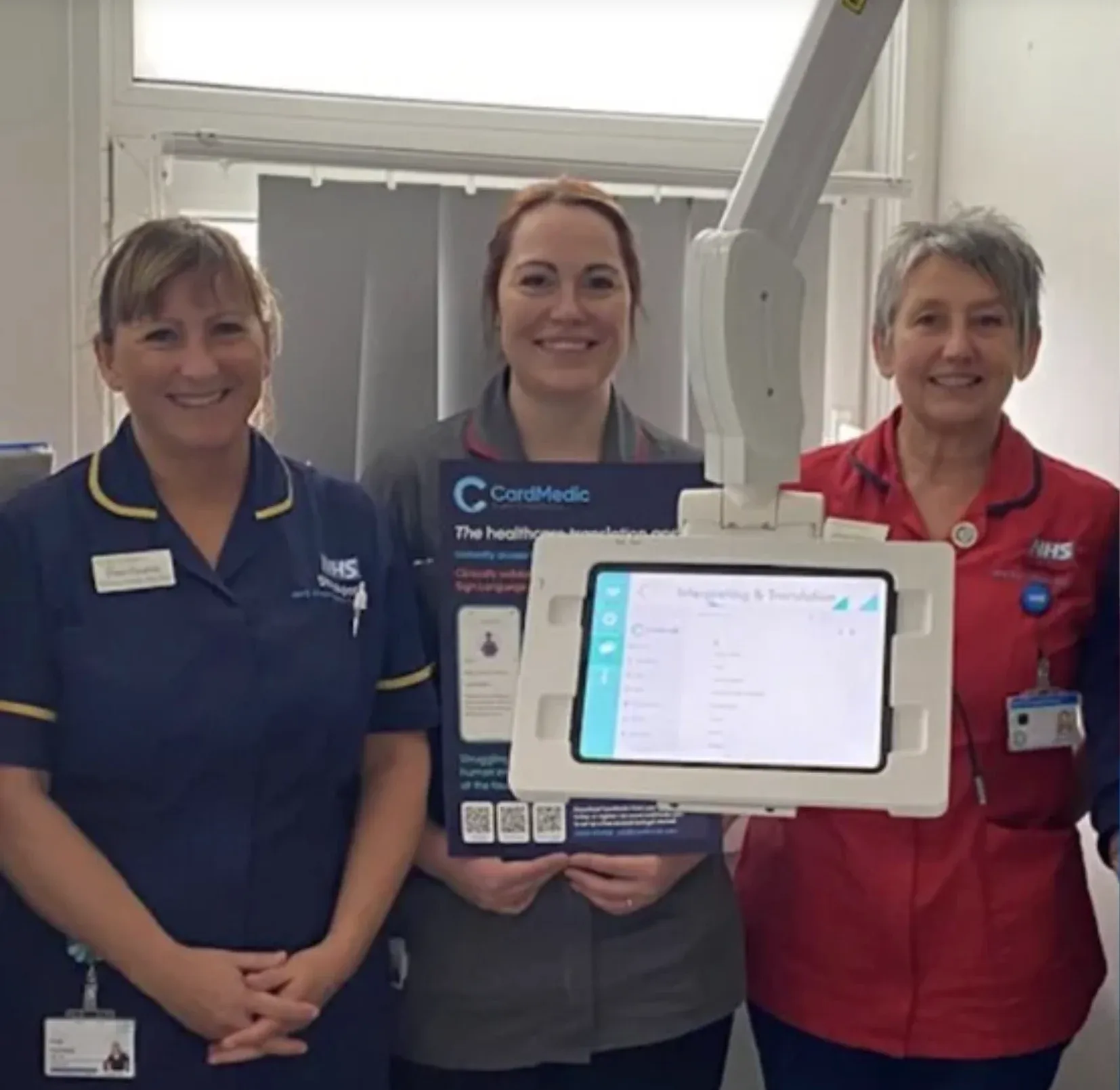 Three members of ward staff with CardMedic open on a tablet in a bedside stand.