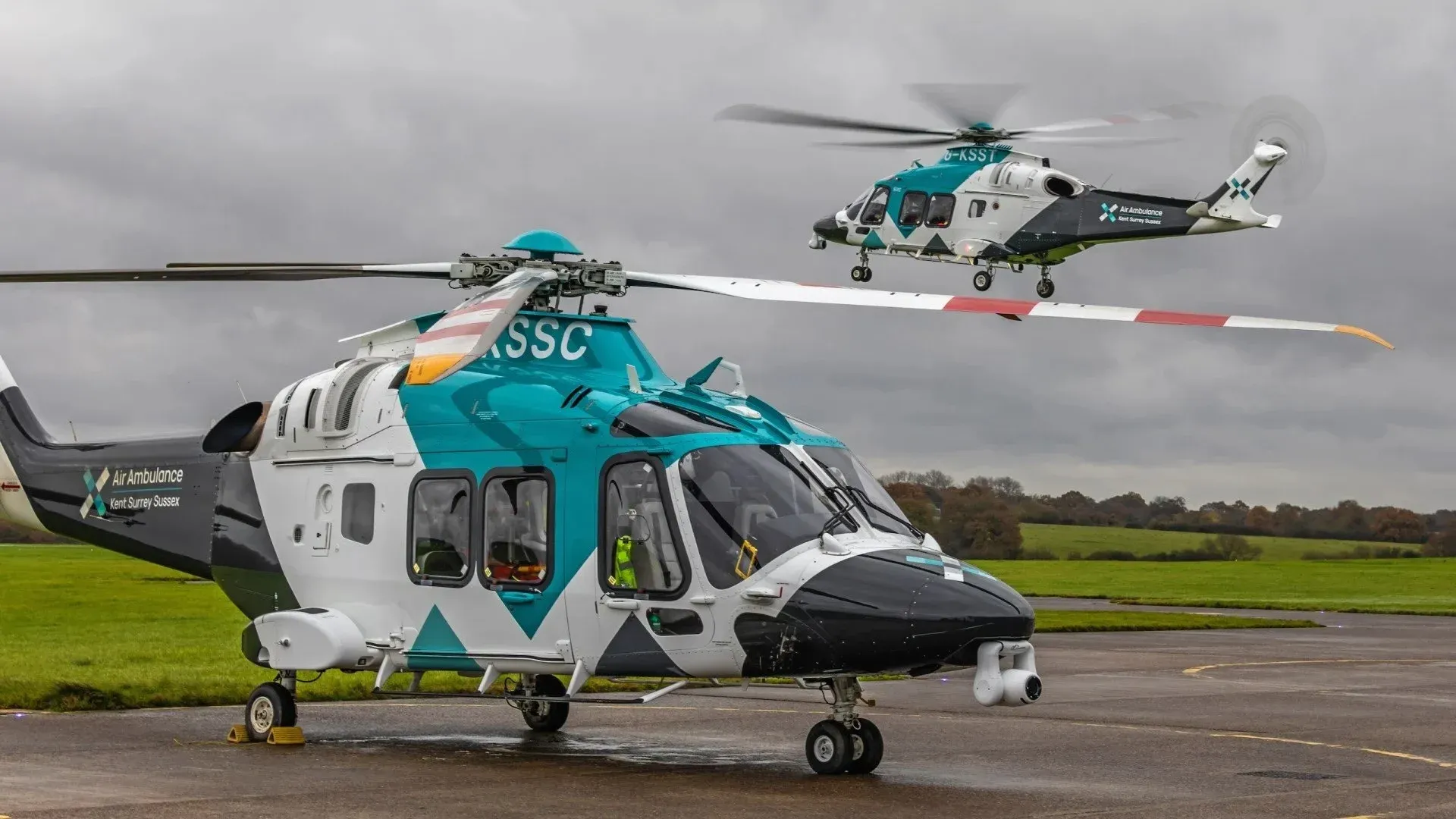 Urgent, emergency and ambulance: two air ambulance helicopters on an airfield.
